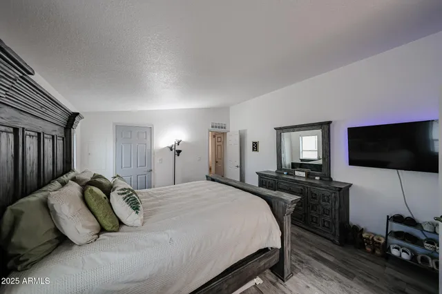 a bedroom with a bed and a flat screen tv