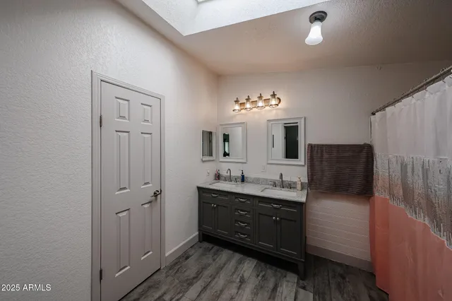 a bathroom with double vanity and a mirror