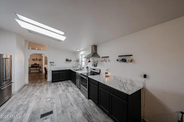 a kitchen with granite countertop a sink cabinets and wooden floor