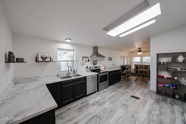 a kitchen with stainless steel appliances granite countertop a sink stove and refrigerator