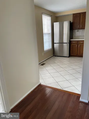 a kitchen with a refrigerator and wooden floor