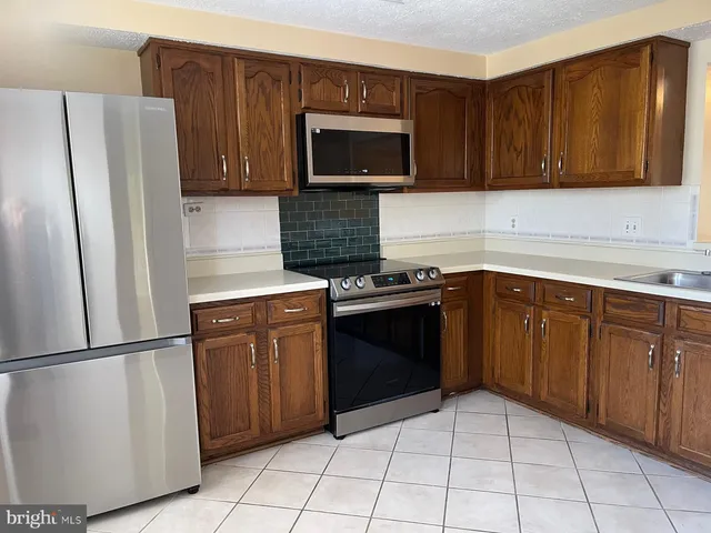 a kitchen with stainless steel appliances granite countertop a refrigerator stove a sink and dishwasher