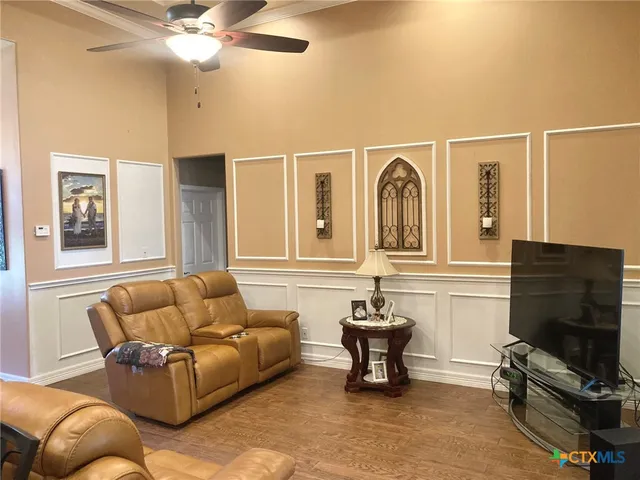 a living room with furniture a flat screen tv and a window
