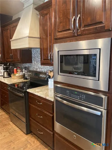 a kitchen with granite countertop a stove and a microwave