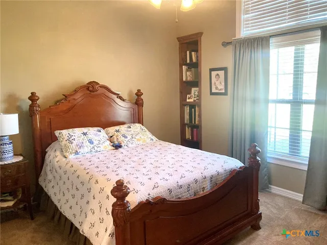 a bed sitting in a bedroom next to a window