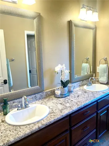 a bathroom with a granite countertop sink and a mirror