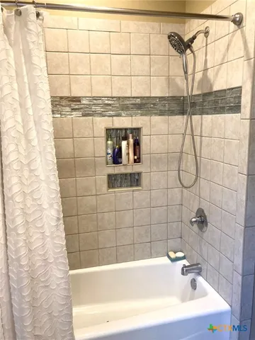 a bathroom with a bathtub and shower