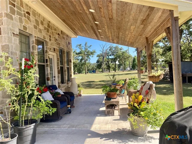 a view of a patio with table and chairs potted plants