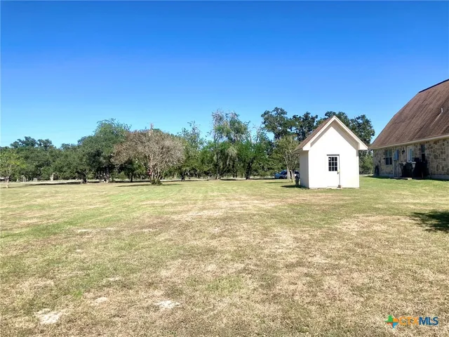 a view of a house with backyard and trees