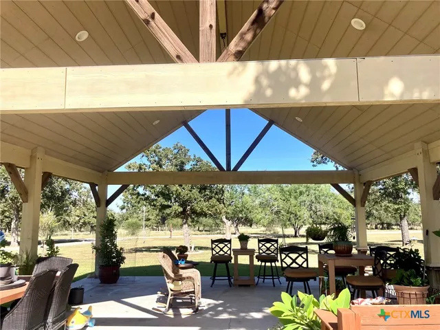 a view of a patio with table and chairs potted plants