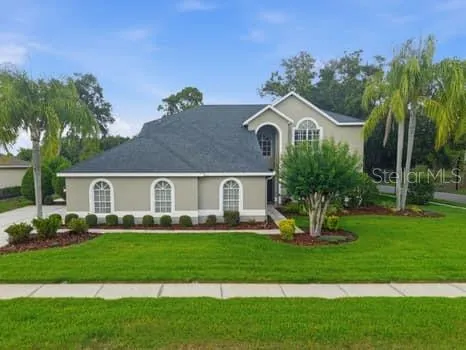 a front view of a house with a yard and trees