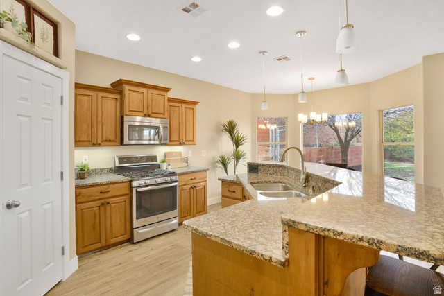 1570 South Rio Virgin Drive Washington, UT 84780 - Photo 17 of 71 Kitchen with stainless steel appliances, a chandelier, light wood-style floors, light stone countertops, and a large island with sink