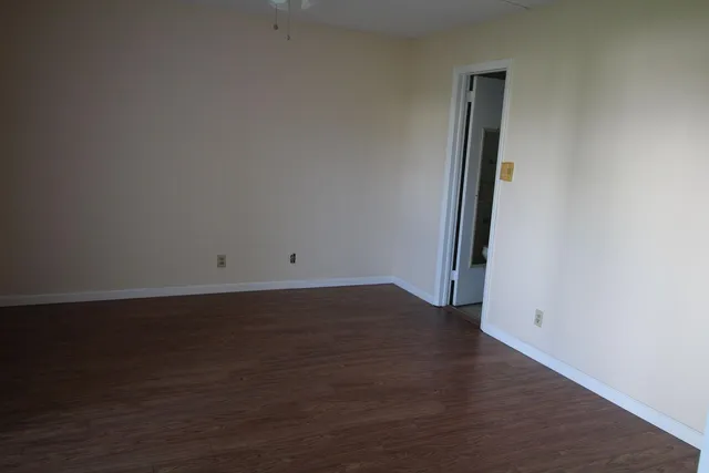 an empty room with wooden floor and sliding door