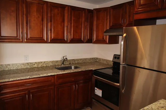 a kitchen with stainless steel appliances granite countertop a refrigerator and a sink