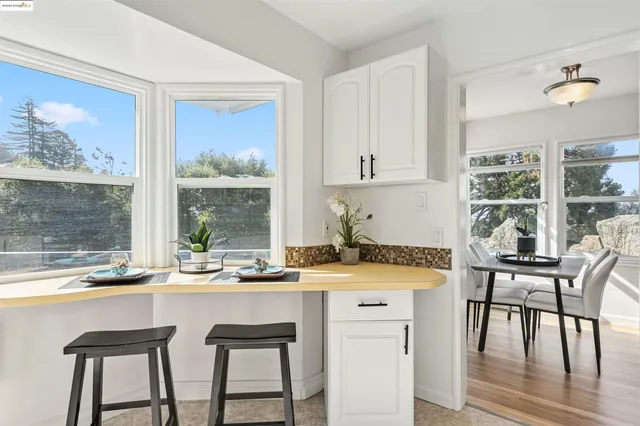 a kitchen with a stove a table and chairs in it