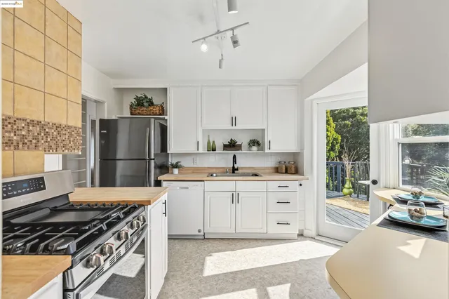 a kitchen with a stove a refrigerator and a stove top oven