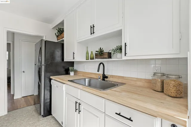 a kitchen with stainless steel appliances granite countertop a sink and a refrigerator