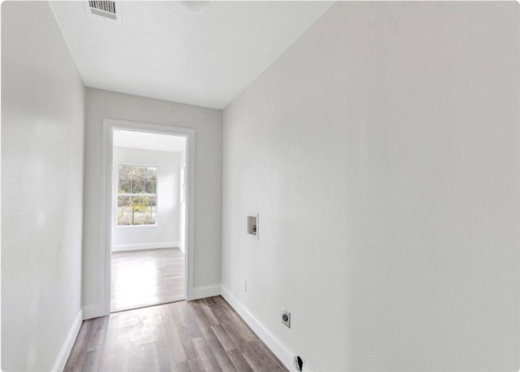 116 Trahan Street Ames, TX 77575 - Photo 12 of 23 a view of an empty room with wooden floor and a window