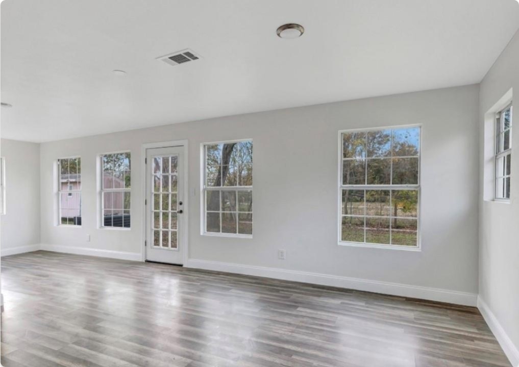 116 Trahan Street Ames, TX 77575 - Photo 13 of 23 a view of an empty room with wooden floor and a window