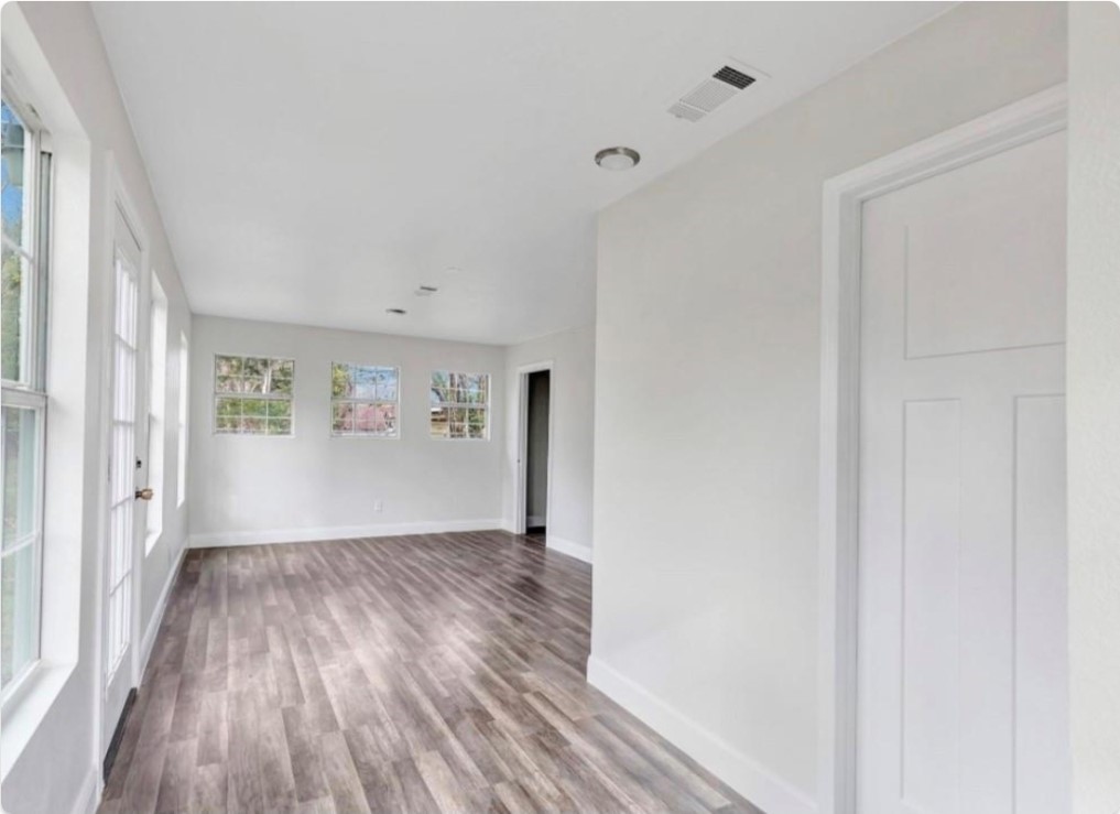 116 Trahan Street Ames, TX 77575 - Photo 14 of 23 a view of a big room with wooden floor and windows