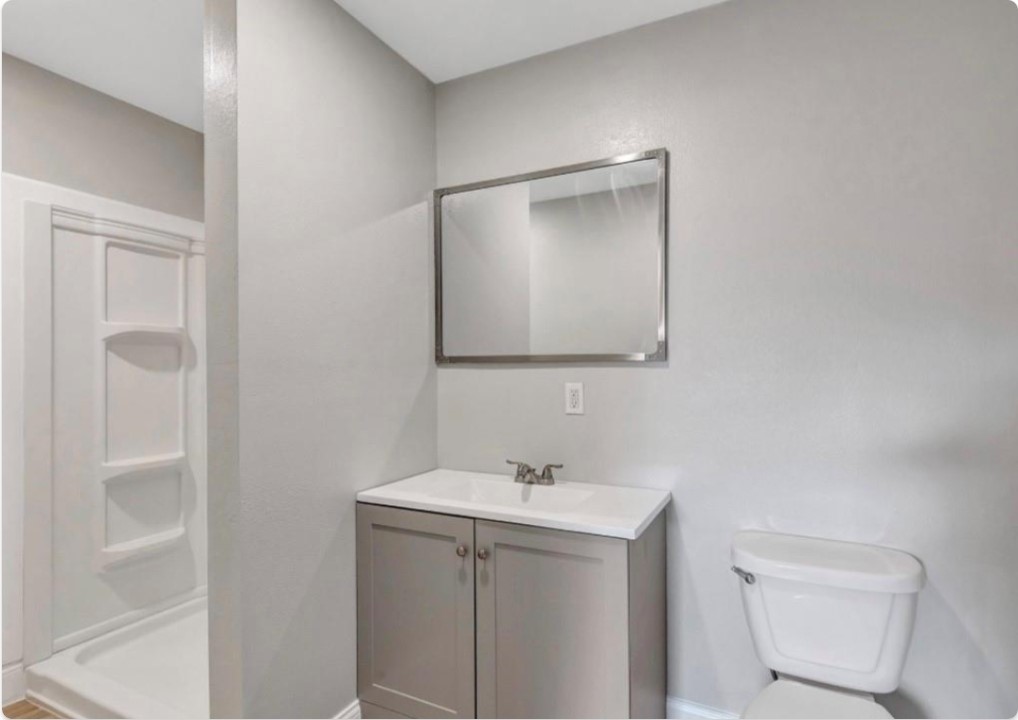 116 Trahan Street Ames, TX 77575 - Photo 20 of 23 a bathroom with a toilet sink and mirror