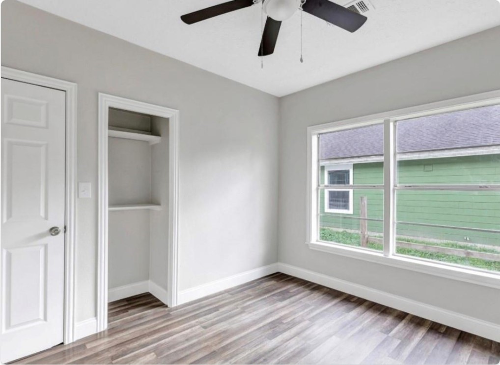 116 Trahan Street Ames, TX 77575 - Photo 6 of 23 a view of an empty room with wooden floor and a window