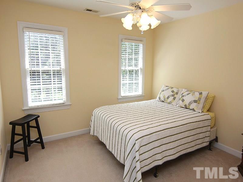 2705 Amstel Way Raleigh, NC 27613 - Photo 19 of 25 a bedroom with a bed and a chandelier