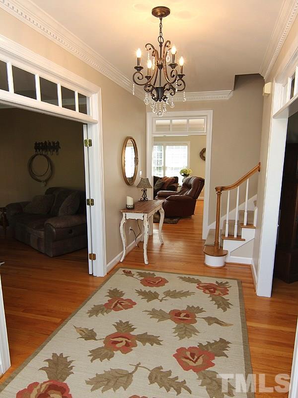 2705 Amstel Way Raleigh, NC 27613 - Photo 4 of 25 a living room with fireplace furniture and a chandelier