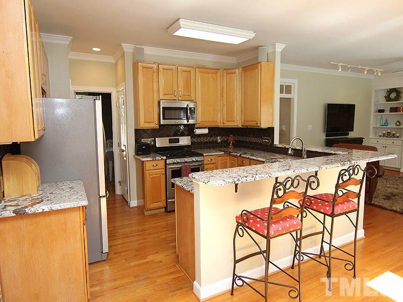 2705 Amstel Way Raleigh, NC 27613 - Photo 9 of 25 a kitchen with stainless steel appliances granite countertop a stove a sink a microwave and a refrigerator