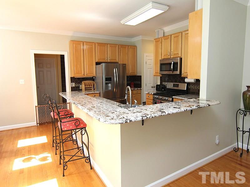 2705 Amstel Way Raleigh, NC 27613 - Photo 10 of 25 a kitchen with stainless steel appliances kitchen island granite countertop a refrigerator and a stove top oven