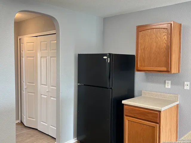 a white refrigerator freezer and a wooden floor