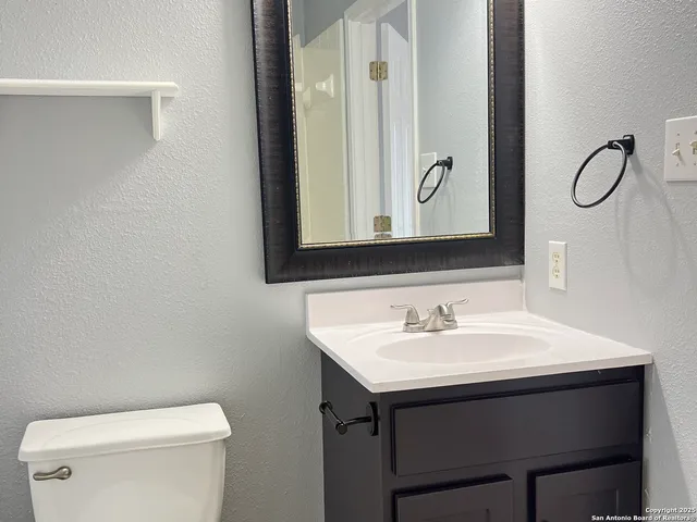 a bathroom with a toilet sink and mirror