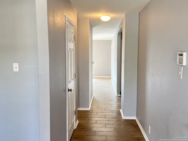 a view of a hallway with wooden floor