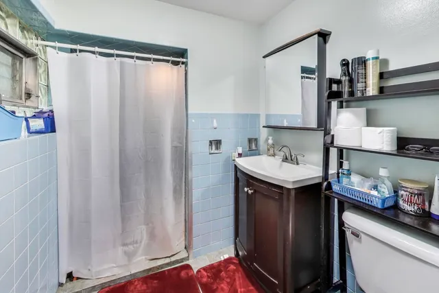 a bathroom with a sink a toilet and shower curtain