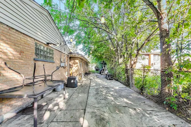a view of a street with potted plants and large trees