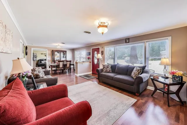 a living room with furniture wooden floor and a large window