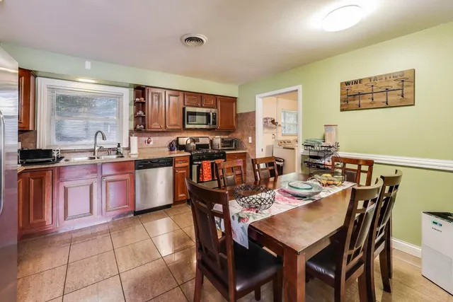 a kitchen with a stove a sink a dining table and chairs