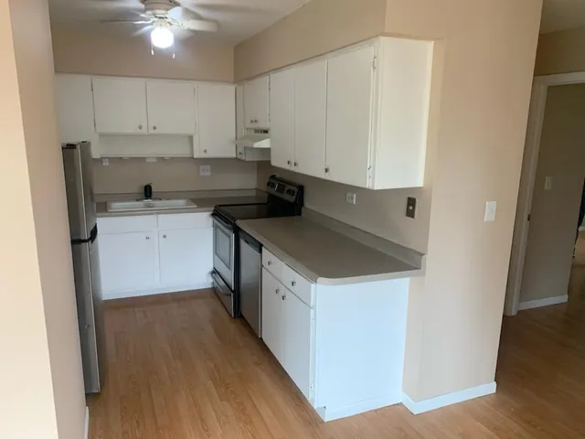 a kitchen with a refrigerator sink and cabinets