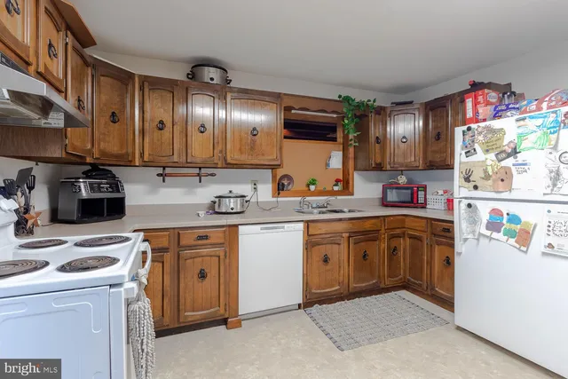 a kitchen with granite countertop lots of clutter and stainless steel appliances