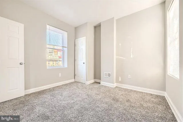 an empty room with windows and closet
