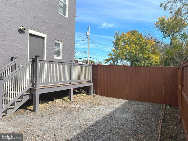 a backyard of a house with wooden floor and fence