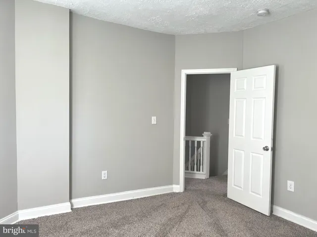 a view of an empty room with closet and a window