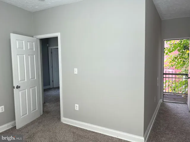 a view of a hallway with wooden floor and closet