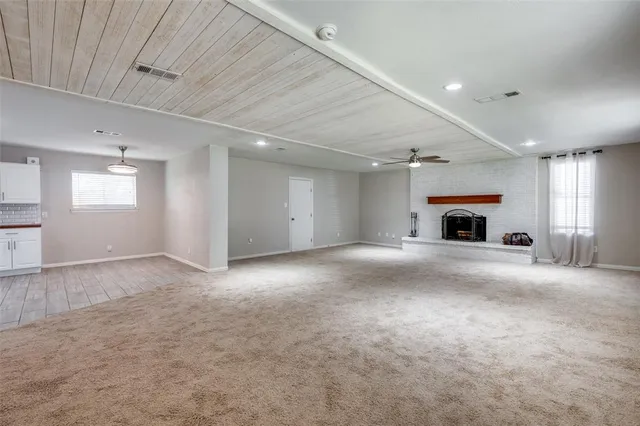 an empty room with fireplace and windows