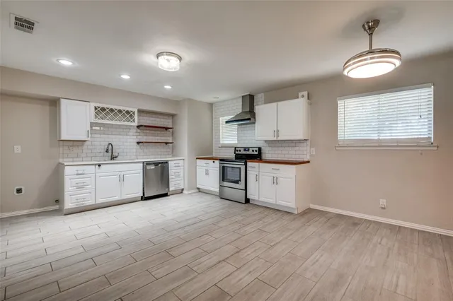 a kitchen with stainless steel appliances and white cabinets