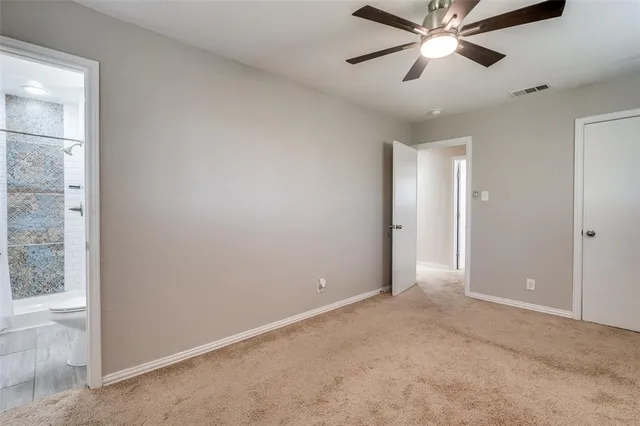 an empty room with closet and a chandelier fan