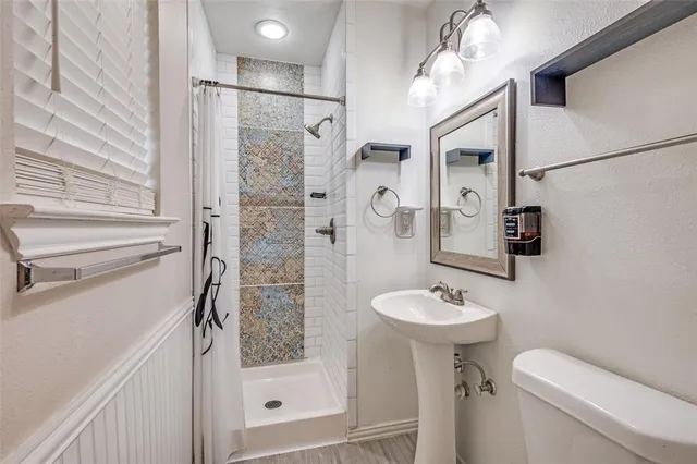 a bathroom with a sink a toilet and shower
