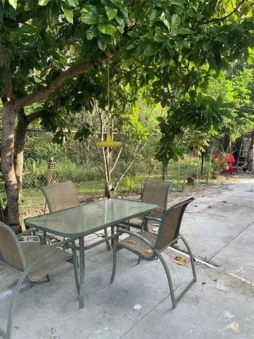 a backyard of a house with table and chairs