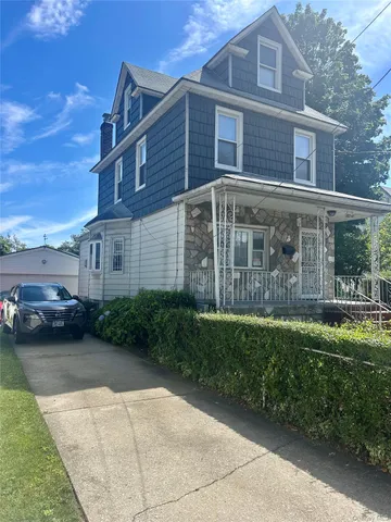 a view of a brick house with a yard next to a road