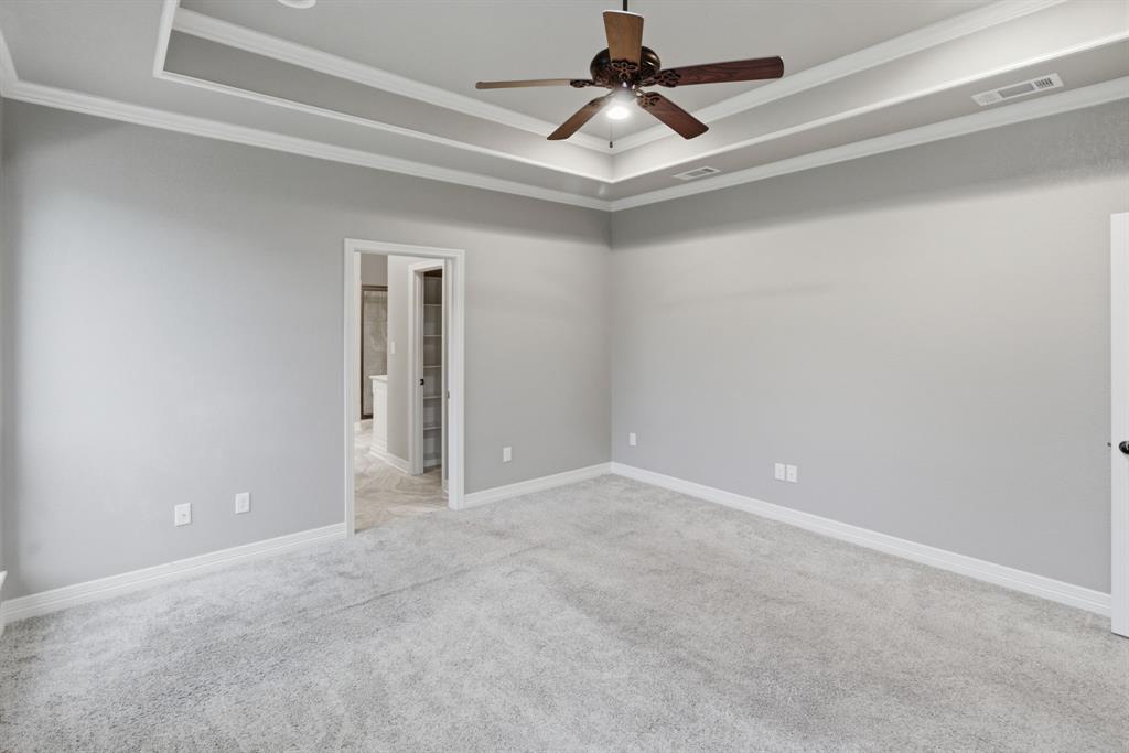 7765 Hickory Spring Lane Tyler, TX 75703 - Photo 23 of 38 Spacious room featuring light gray walls, light gray carpet flooring, and a tray ceiling with crown molding